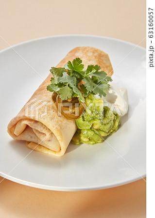Homemade pancake roll with spicy guacamole and white sauces. 63160057