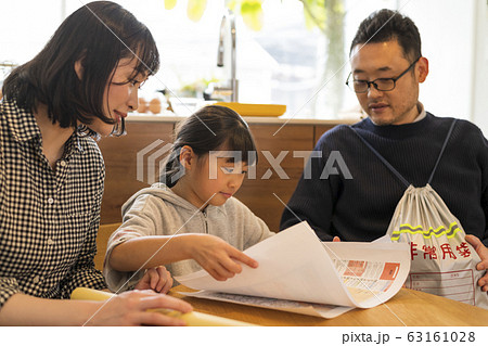 ハザードマップを見ながら避難経路を確認する娘を見守る夫婦 63161028