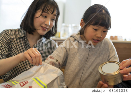 非常用持ち出し袋に避難物資を詰め込む子供 63161038