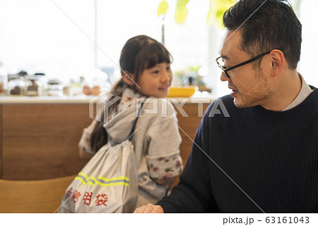 子供が背負う非常用持ち出し袋の状態を確認する父親 63161043