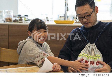 完成した非常持ち出し袋にはしゃぐ親子 63161273