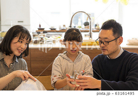 非常持ち出し袋に荷物を入れる子どもを見守る夫婦 非常持ち出し袋に荷物を入れる子どもを見守る夫婦 63161495