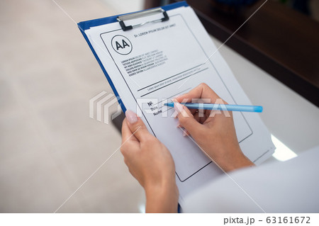 Close up of receptionist holding pen while making notes Close up of receptionist holding pen while making notes 63161672
