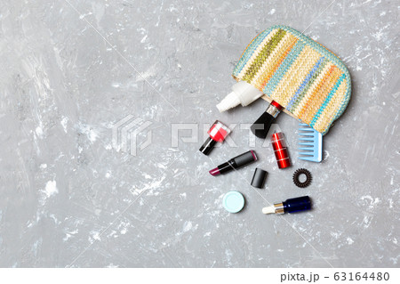 Make up products spilling out of cosmetics bag on Make up products spilling out of cosmetics bag on 63164480