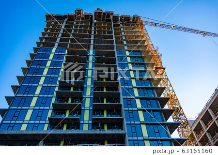 Monolite concrete building under constraction on blue sky background. Monolite concrete building under constraction on blue sky background. 63165160