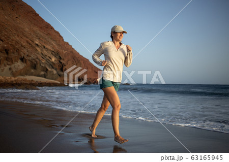 Young woman running on the La Tejita beach 63165945