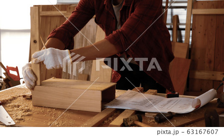 Carpenter fitting pieces of boards together at site. Carpenter fitting pieces of boards together at site. 63167607