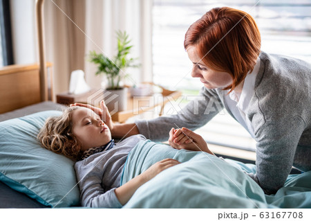 Caring mother visiting small girl daughter in bed in hospital. Caring mother visiting small girl daughter in bed in hospital. 63167708