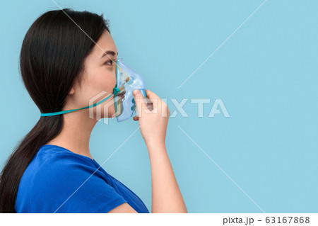 Young adult asian girl with breathing oxygen mask 63167868