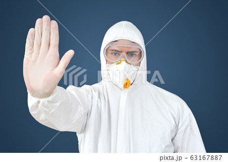 Doctor in protective suit and face mask making stop gesture Doctor in protective suit and face mask making stop gesture 63167887