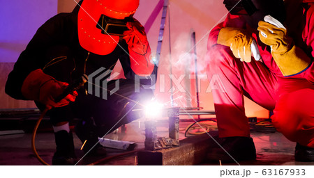Male welders working together at site. 63167933