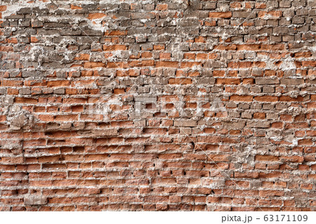 Surface of the wall is made of red crumbling brick 63171109