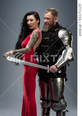 Beautiful girl in a red dress and knight in armor Beautiful girl in a red dress and knight in armor 63171129