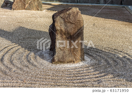 Japanese dry rock zen landscape garden, or karesansui, with raked sand or gravel to represent ripples in water. Kurikarafudoji temple, Tsubata, Japan. Japanese dry rock zen landscape garden, or karesansui, with raked sand or gravel to represent ripples in water. Kurikarafudoji temple, Tsubata, Japan. 63171950