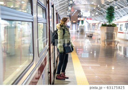 Woman in subway with medical mask on her head as a passenger. Protection against viral diseases 63175825