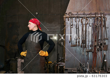woman blacksmith metal artist in her forge 63176303
