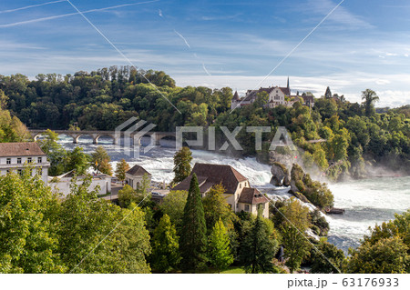 Rheinfall the large and powerful waterfall surround with green forest and blue sky background view from Neuhausen am Rheinfall railway station in switzerlad 63176933