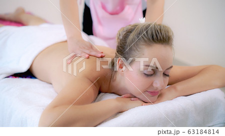 Woman gets back massage spa by massage therapist. 63184814
