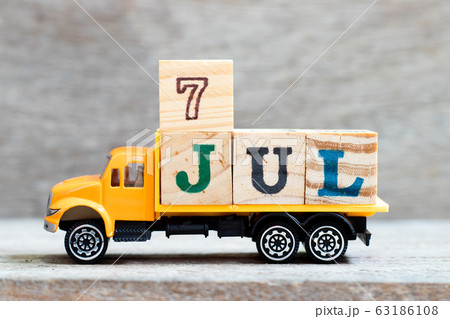 Truck hold letter block in word 7jul on wood background Truck hold letter block in word 7jul on wood background 63186108