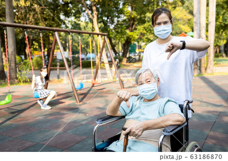 Senior mother and daughter show thumbs down,family wearing medical mask,asian people prevent the Covid-19 infection,epidemic,spread of germs,outbreak Coronavirus,concept of Covid-19 virus quarantine Senior mother and daughter show thumbs down,family wearing medical mask,asian people prevent the Covid-19 infection,epidemic,spread of germs,outbreak Coronavirus,concept of Covid-19 virus quarantine 63186870