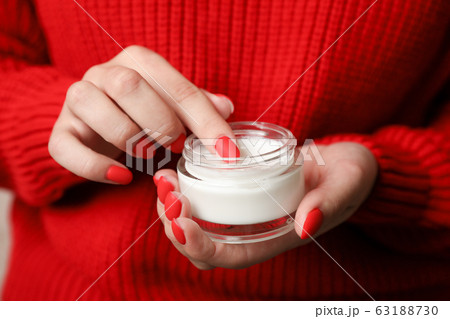 Woman holding jar of moisturizing cream, closeup. 63188730