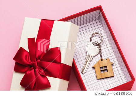 House key in a box on a pink background. Real estate gift concept 63189916