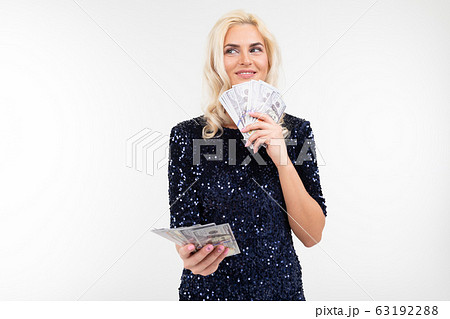 portrait of a successful woman in a dress holding a bunch of money in her hands on a white portrait of a successful woman in a dress holding a bunch of money in her hands on a white 63192288