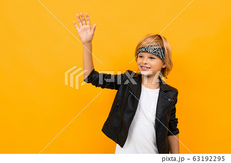 Stylish young boy in black jacket and white t-shirt rejoices Stylish young boy in black jacket and white t-shirt rejoices 63192295