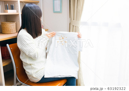 食べこぼしで汚れた服を持つ女性 63192322