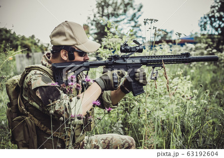A military man or airsoft player in a camouflage 63192604