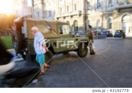 Blurred Milan city central square with lack of people and army vehicle and soldiers patrol due nationwide quarantine of coronavirus outbreak alert danger. Restrictions measures prevent virus spread 63192779
