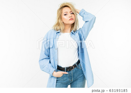 pretty blonde girl in blue jeans shirt smiling cute on a white studio background 63193185