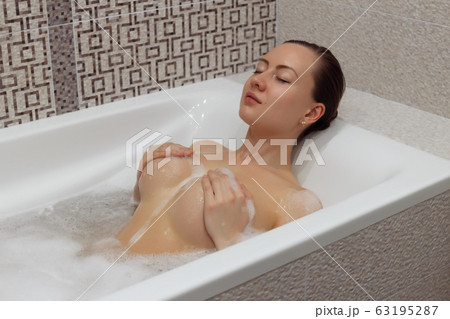 Nude girl takes a bubble bath 63195287
