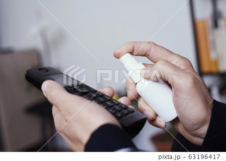 man disinfecting a portable telephone man disinfecting a portable telephone 63196417