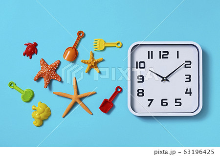 clock and beach toys on a blue background clock and beach toys on a blue background 63196425