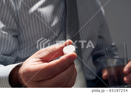 businessman with a pill, hands close view - businessman with a pill, hands close view - 63197254