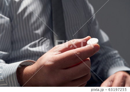 businessman with a pill, hands close view - businessman with a pill, hands close view - 63197255