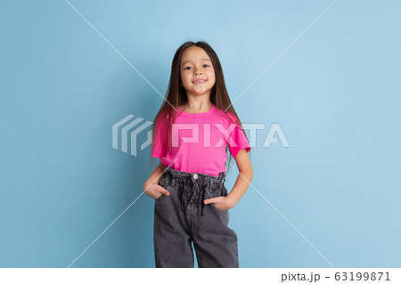 Caucasian little girl's portrait on blue studio background 63199871