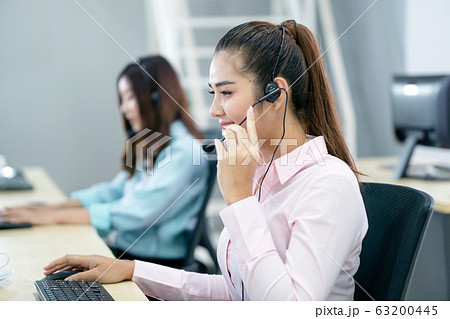 Young female operator with headphone Young female operator with headphone 63200445