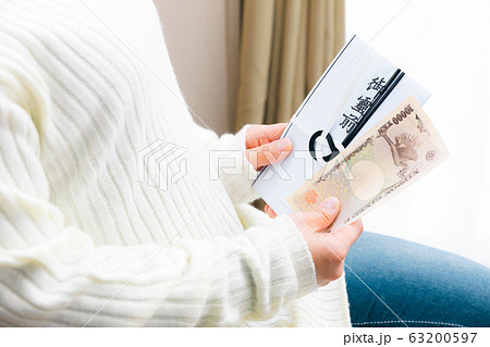 香典　一万円を準備する女性　ご霊前 63200597