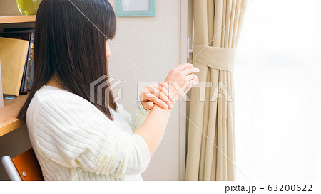 手首を抑える女性　様々な症状　16:9 63200622