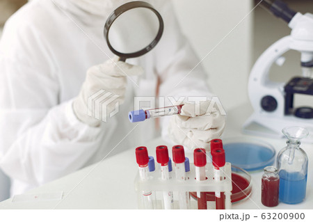 Scientist in coverall clothing is examining coronavirus sample in a laboratory Scientist in coverall clothing is examining coronavirus sample in a laboratory 63200900
