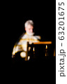 Russia, 2020, the Orthodox Church, the priest is out of focus (very blurry), reads a prayer, a prayer book. Three burning candles in the foreground 63201675
