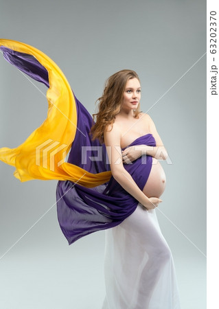 Pregnant woman covering breast and touching belly Pregnant woman covering breast and touching belly 63202370