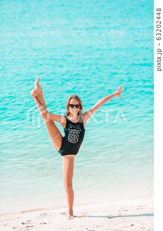 Adorable active little girl at beach during summer vacation Adorable active little girl at beach during summer vacation 63202448