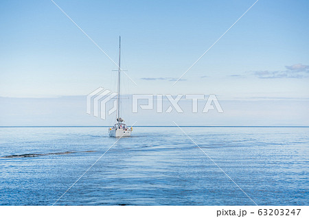Yacht sailing alone in the flat sea of Hebrides islands. Yacht sailing alone in the flat sea of Hebrides islands. 63203247