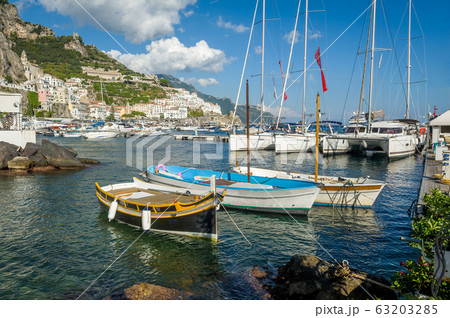 Traditional boats and modern yachts docked at Amalfi marina 63203285