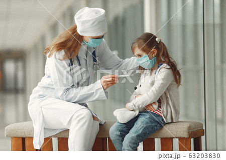Doctor and a child in protective masks are in hospital 63203830