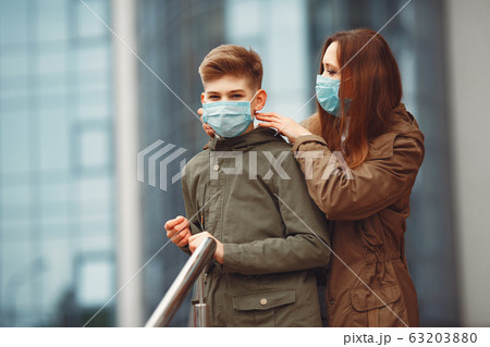 Mother and son are wearing disposable masks 63203880