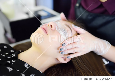 Beautician making eyelash lamination procedures. Beautician making eyelash lamination procedures. 63204827